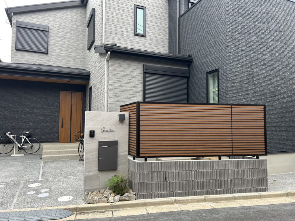 木目調フェンスと大判タイル門柱が印象的なホテルライク外構の施工例